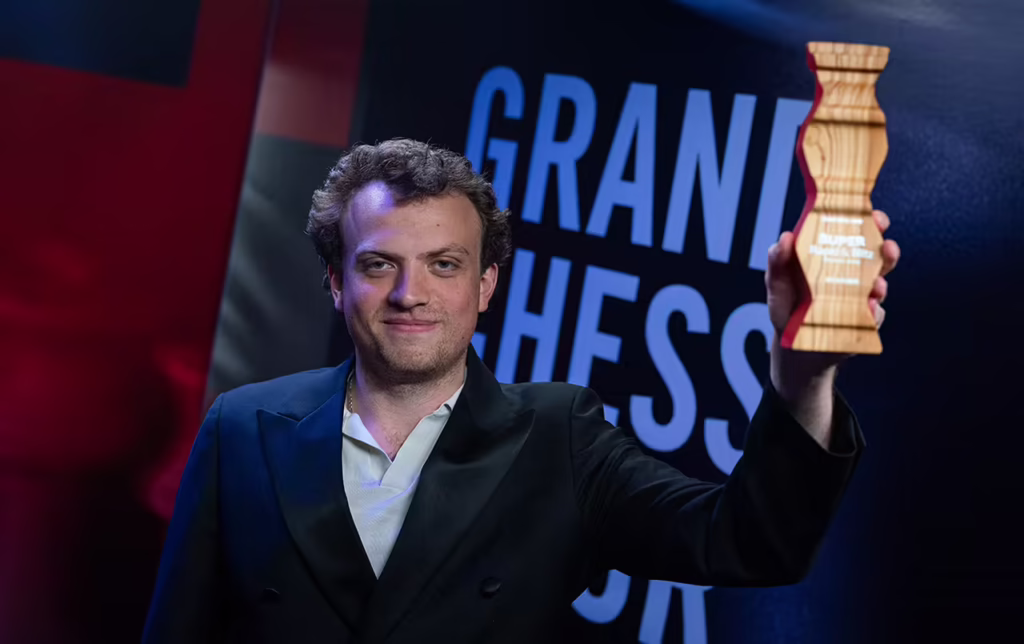 GM Hans Niemann holding the 2026 GCT Poland Rapid & Blitz championship trophy.